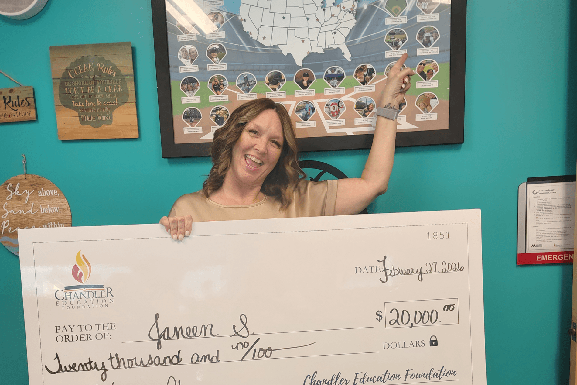 CEF raffle winner Janeen Scaringelli holding an oversized $20,000 check, pointing to map of MLB parks.