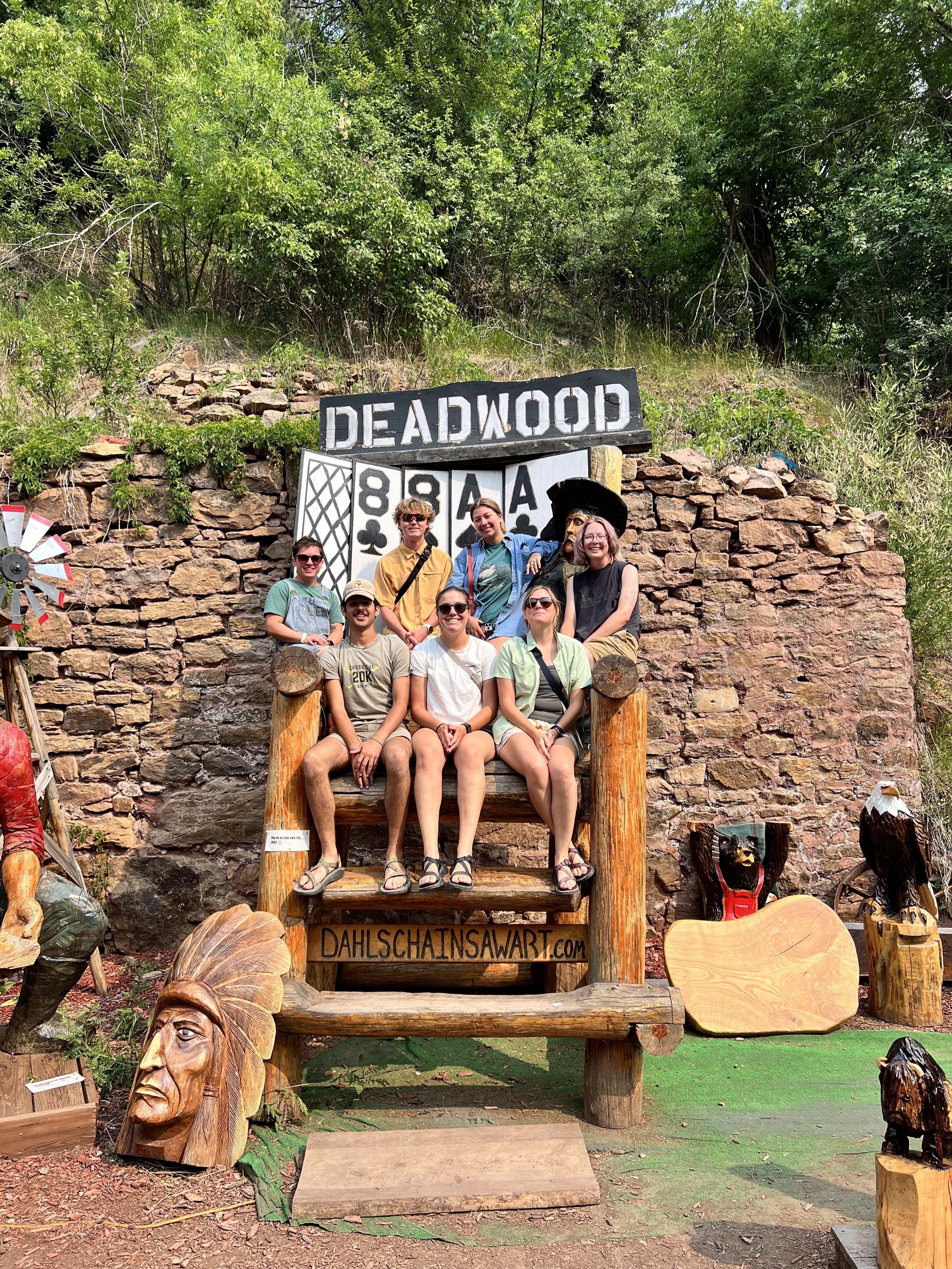 A crew poses in front of a sign, "Deadwood"