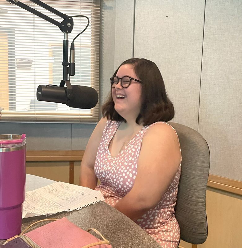 Person laughing in front of a microphone