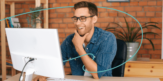 A man smiling at his computer