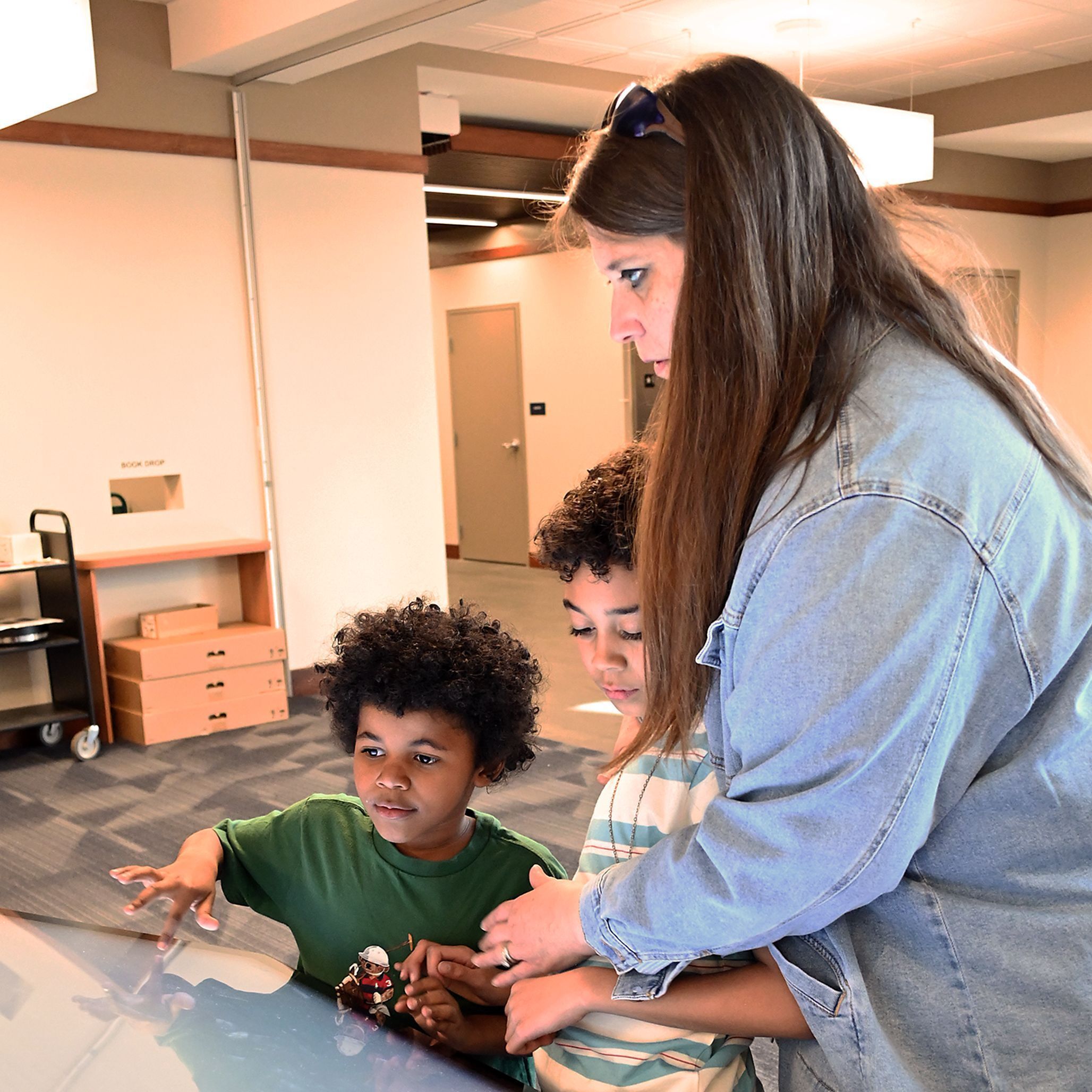 Woman and her two boys using library wayfinding.