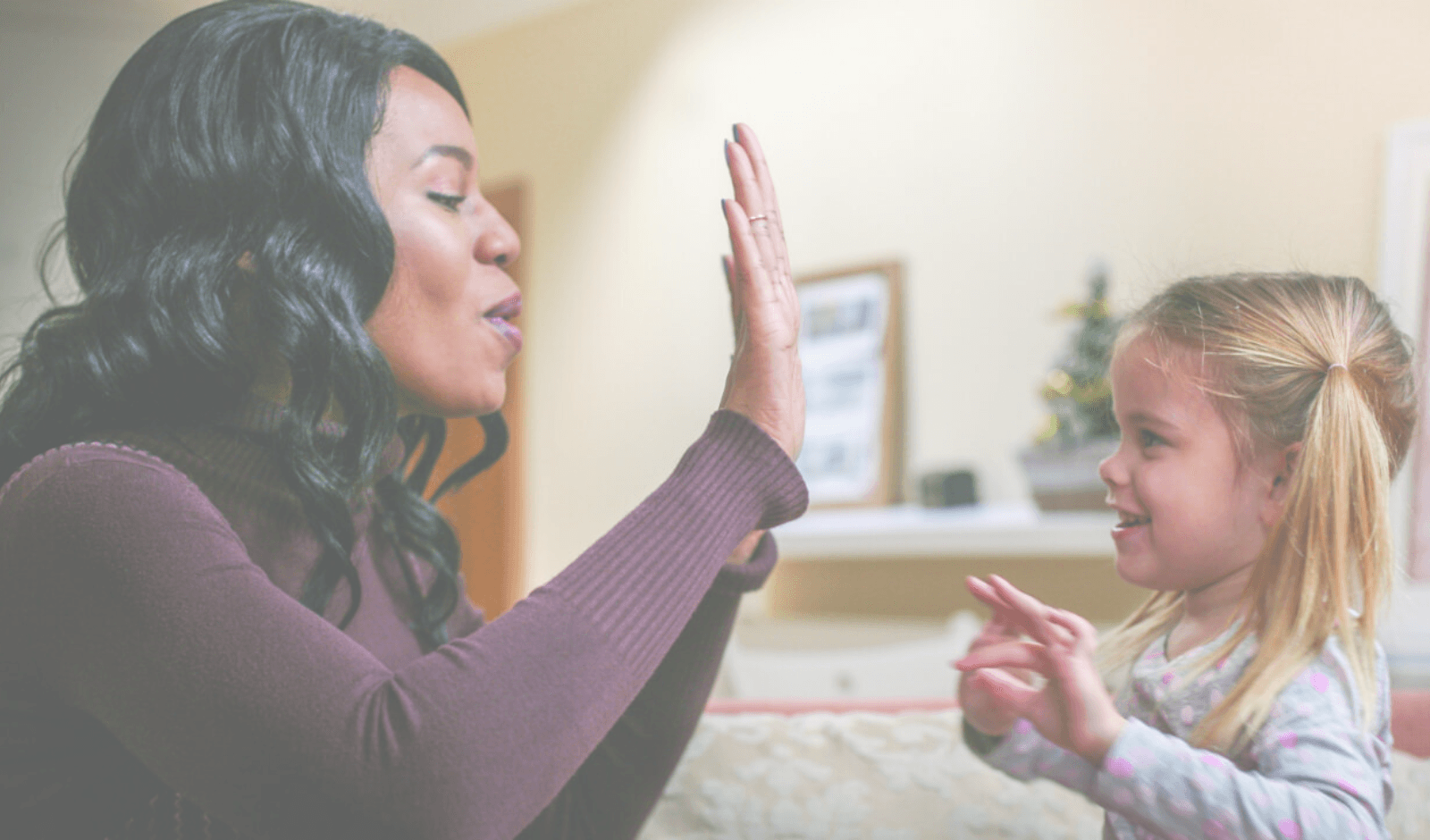 A CASA mentor high-fiving a young girl.
