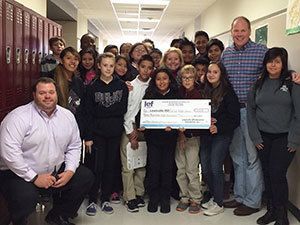 Students & teachers with a big check.