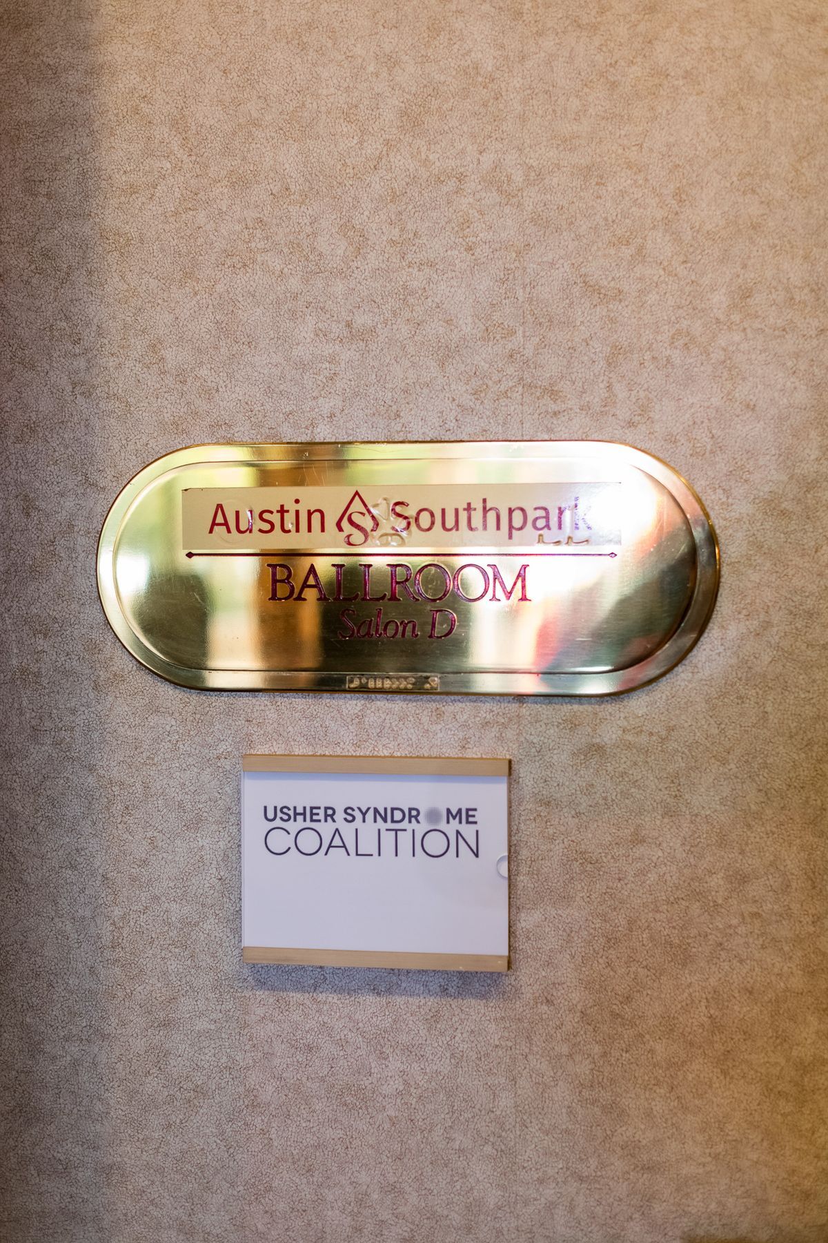 The Usher Syndrome Coalition's logo is seen under the Austin Southpark Ballroom's sign. 