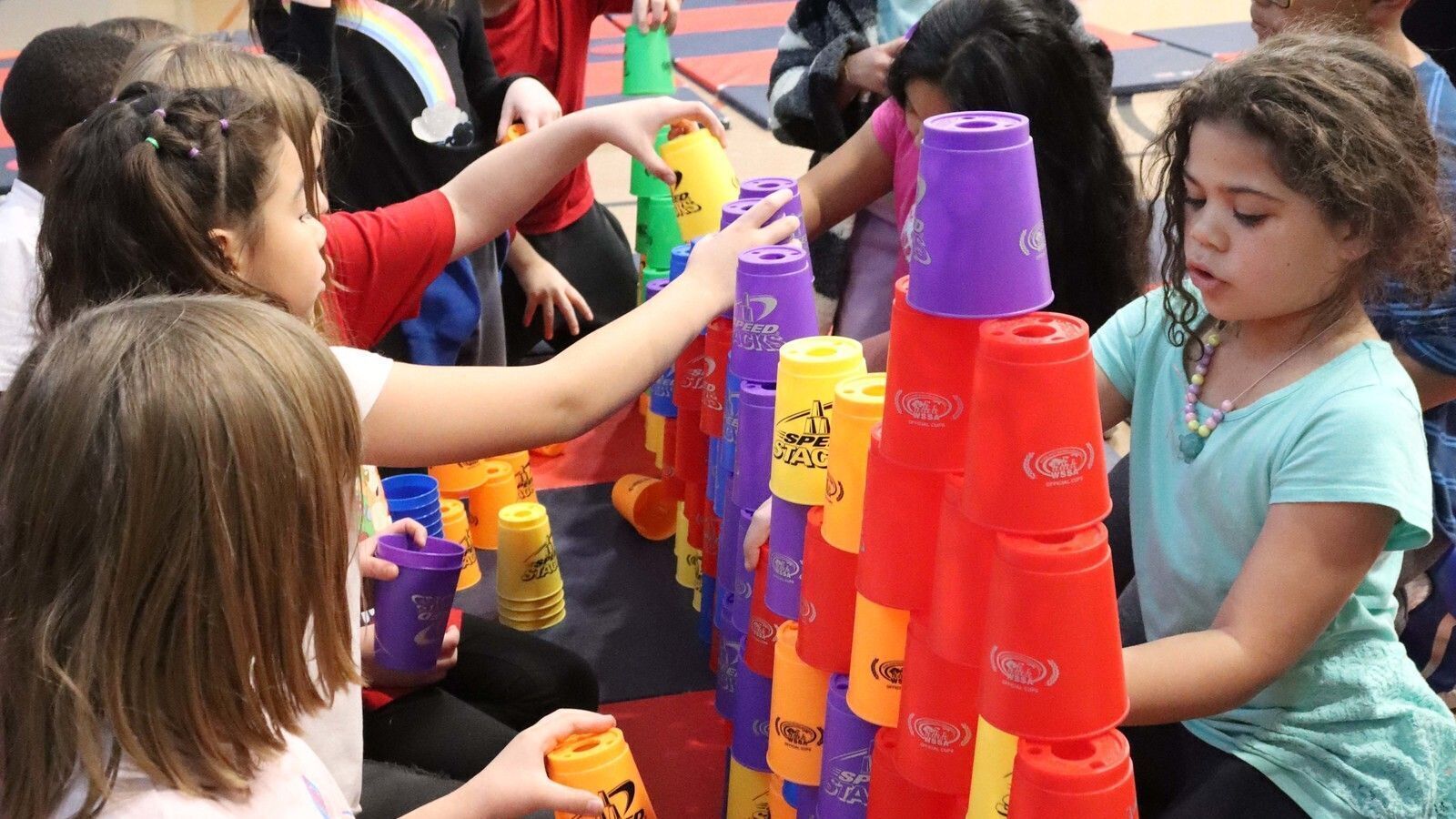 3 girls stacking cups together in gym class