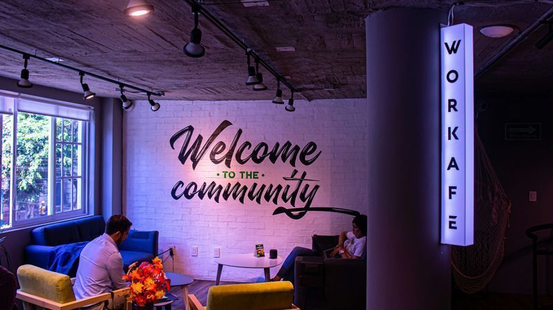 Typography-driven office wall graphics on a brick surface spelling out core values, showcasing organic and engaging office branding ideas.