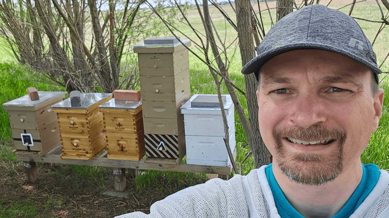 Selfie of Pastor Brian Jack standing in front of his honey bee hives 