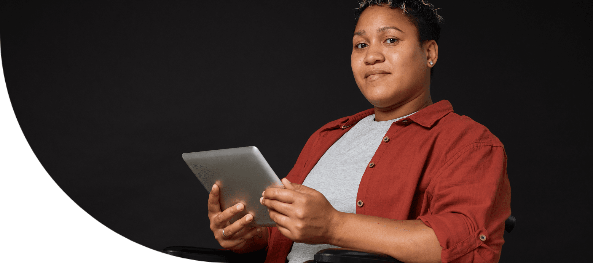 boy and girl sitting at desks with a tablet