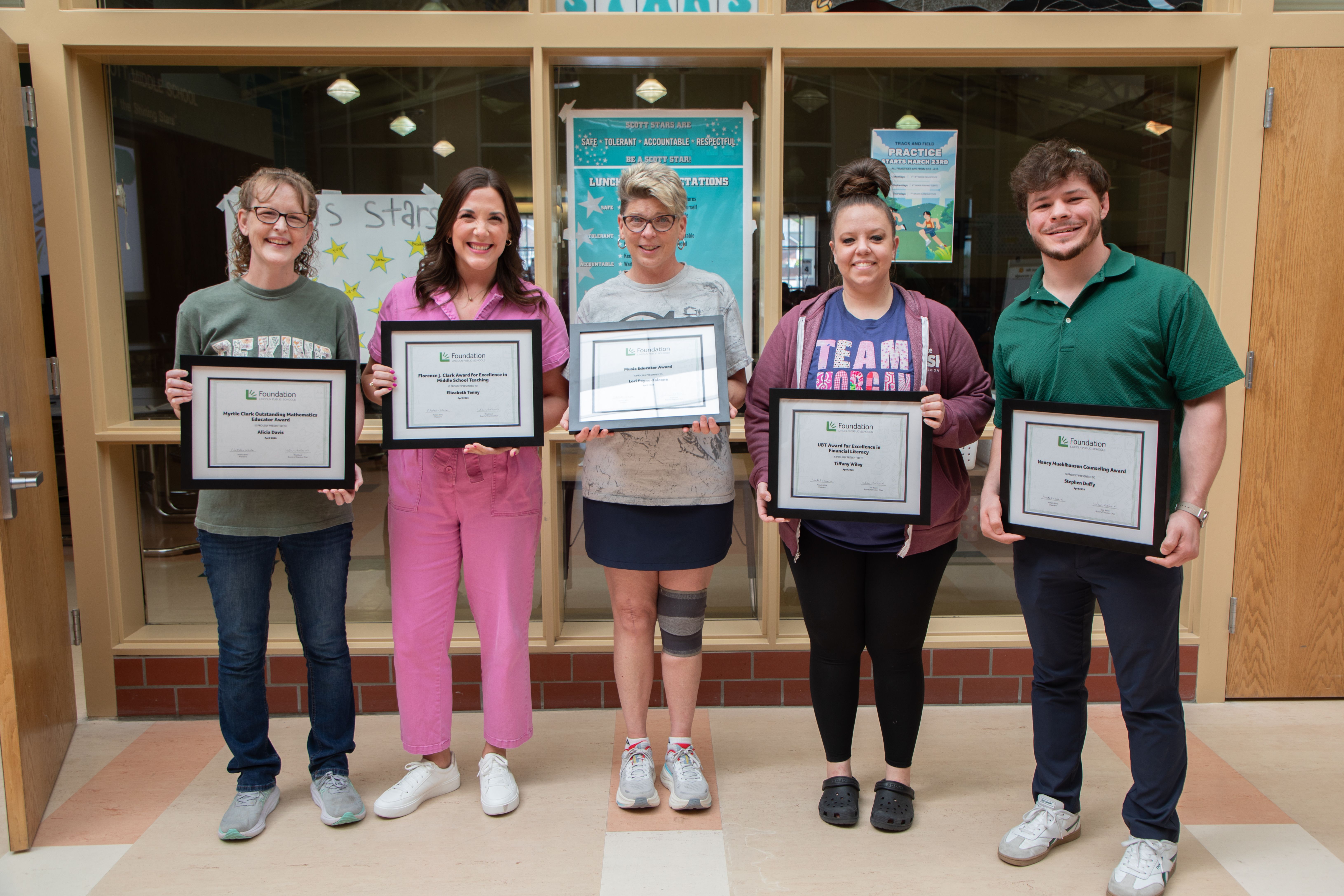 Scott's five educator award winners posing with their framed certificates