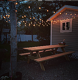 Patio porch with tea lights hanging from birchwood posts