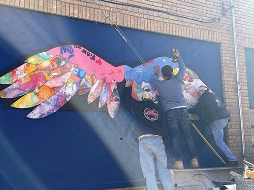 People installing a mural.