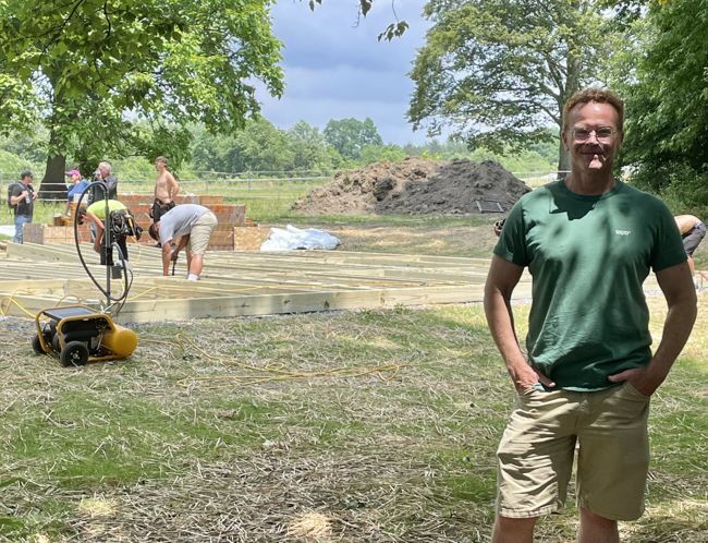Jonathon Snipes, Owner of the education center, looks into the camera as construction work on the pavilion continues to the back and left of the picture.
