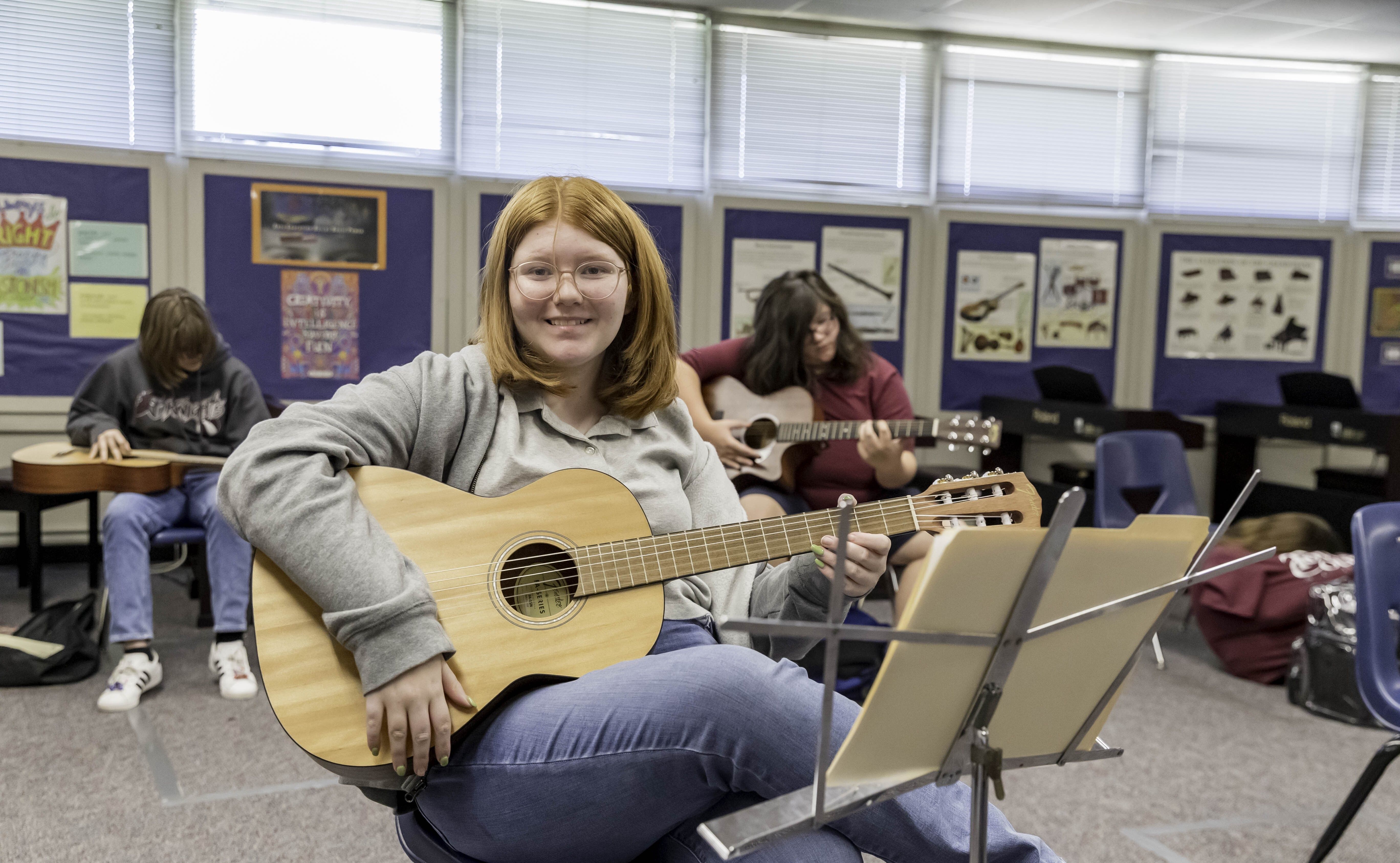 Student playing a guitar