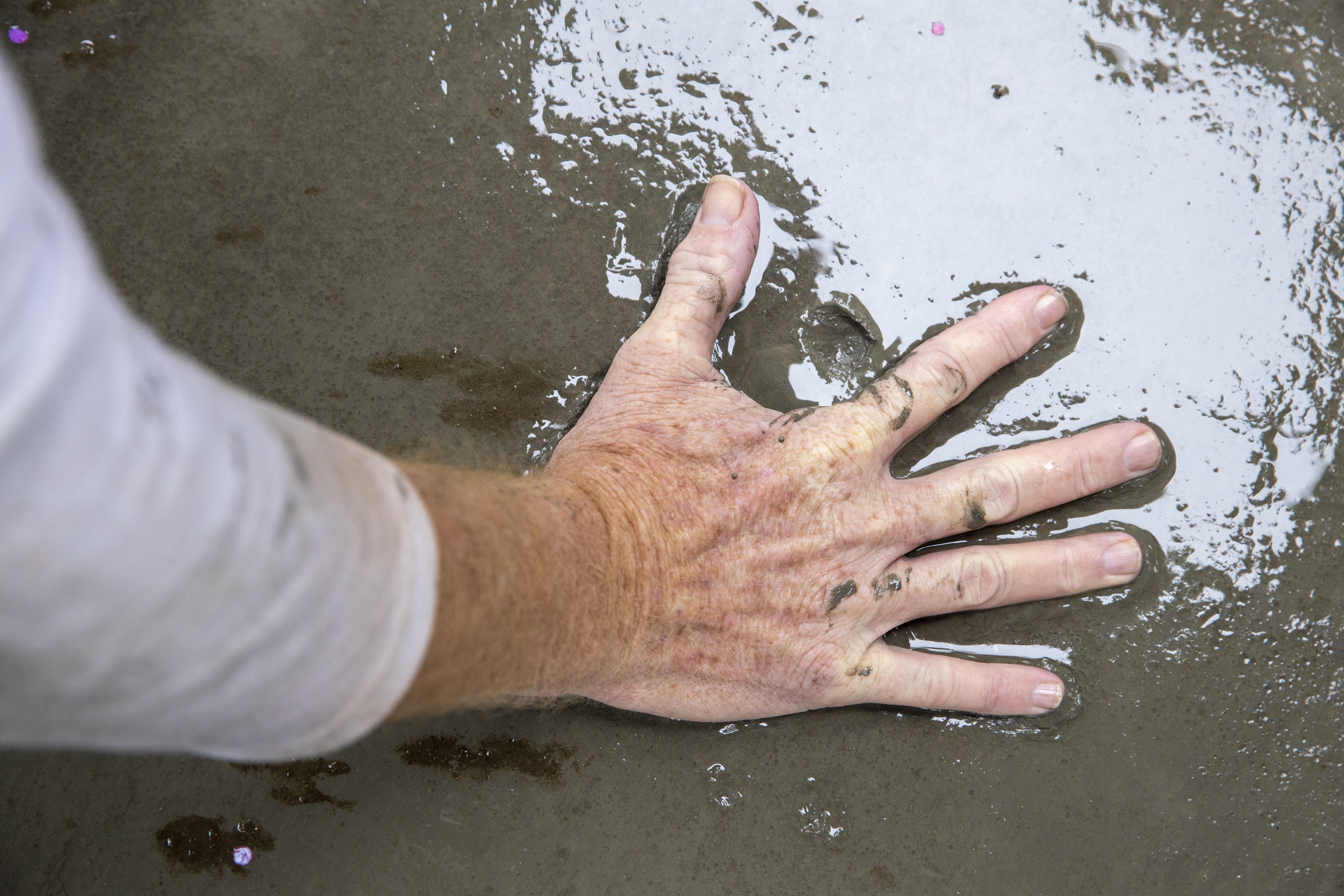 Hand pressing on wet concrete 