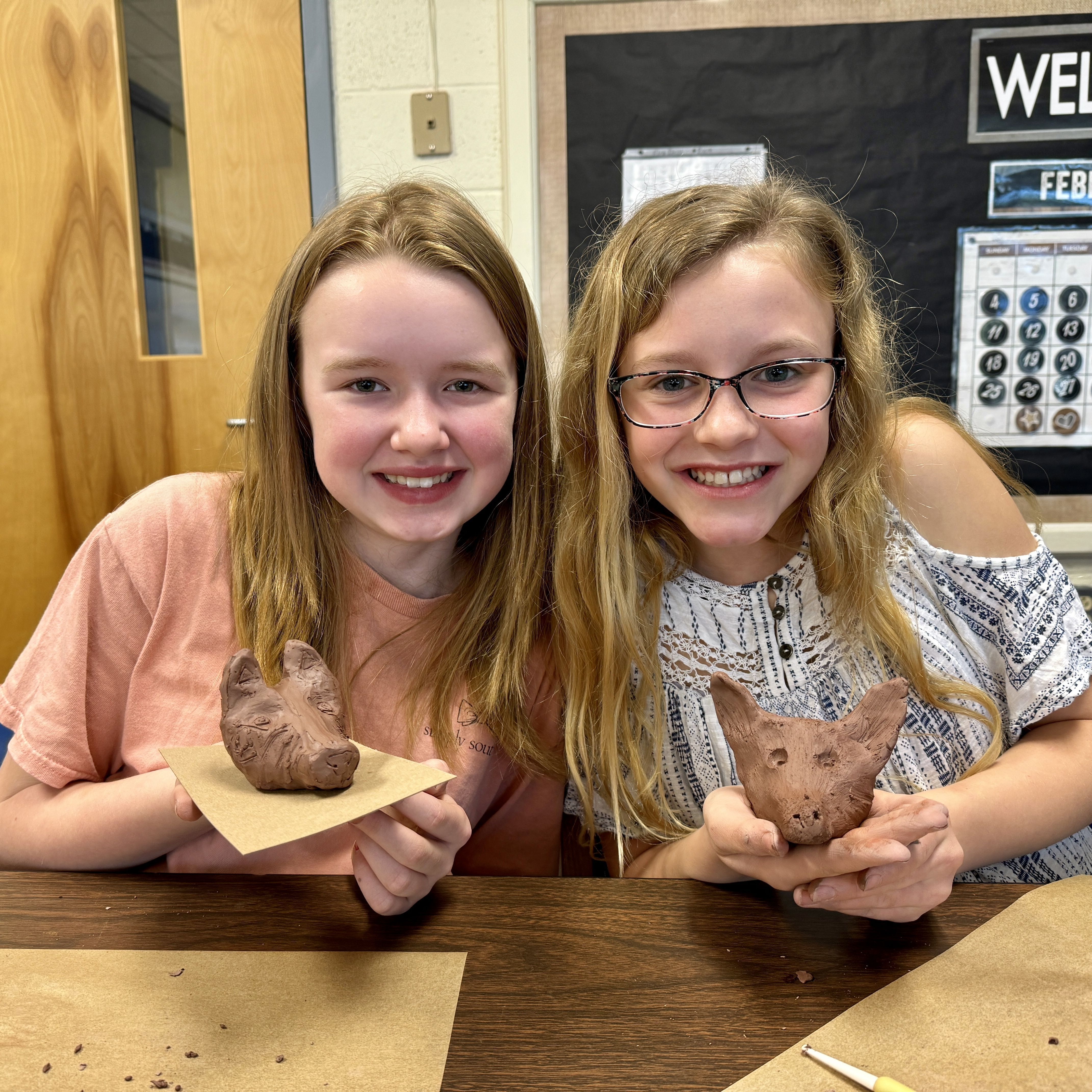 Excited students displaying their American Red Wolf clay sculptures