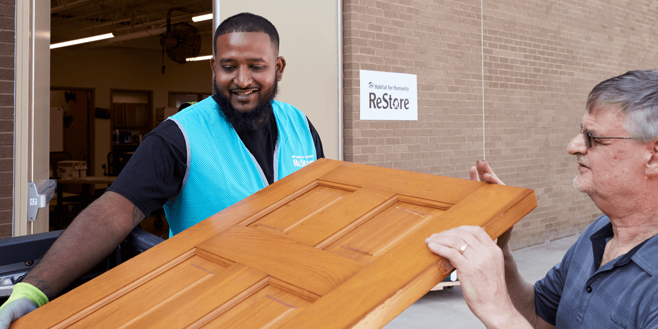 community volunteers unloading donated furniture at Habitat ReStore drop-off area.