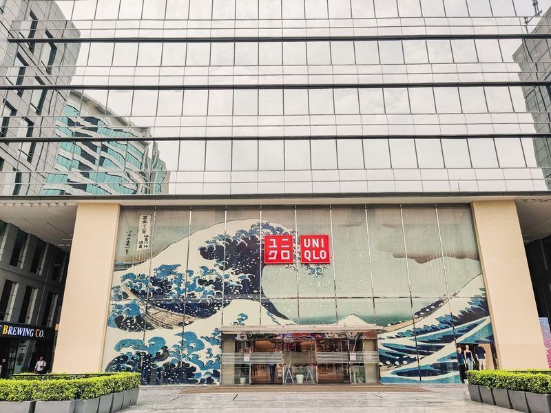 Instagrammable wall idea on a Uniqlo storefront featuring a large wave-inspired mural across glass panels for eye-catching retail branding.