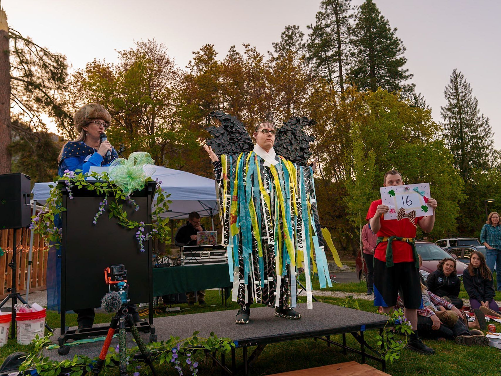 A 2026 Trashion Show adult participant dressed in streamers and wings on the stage during the show.