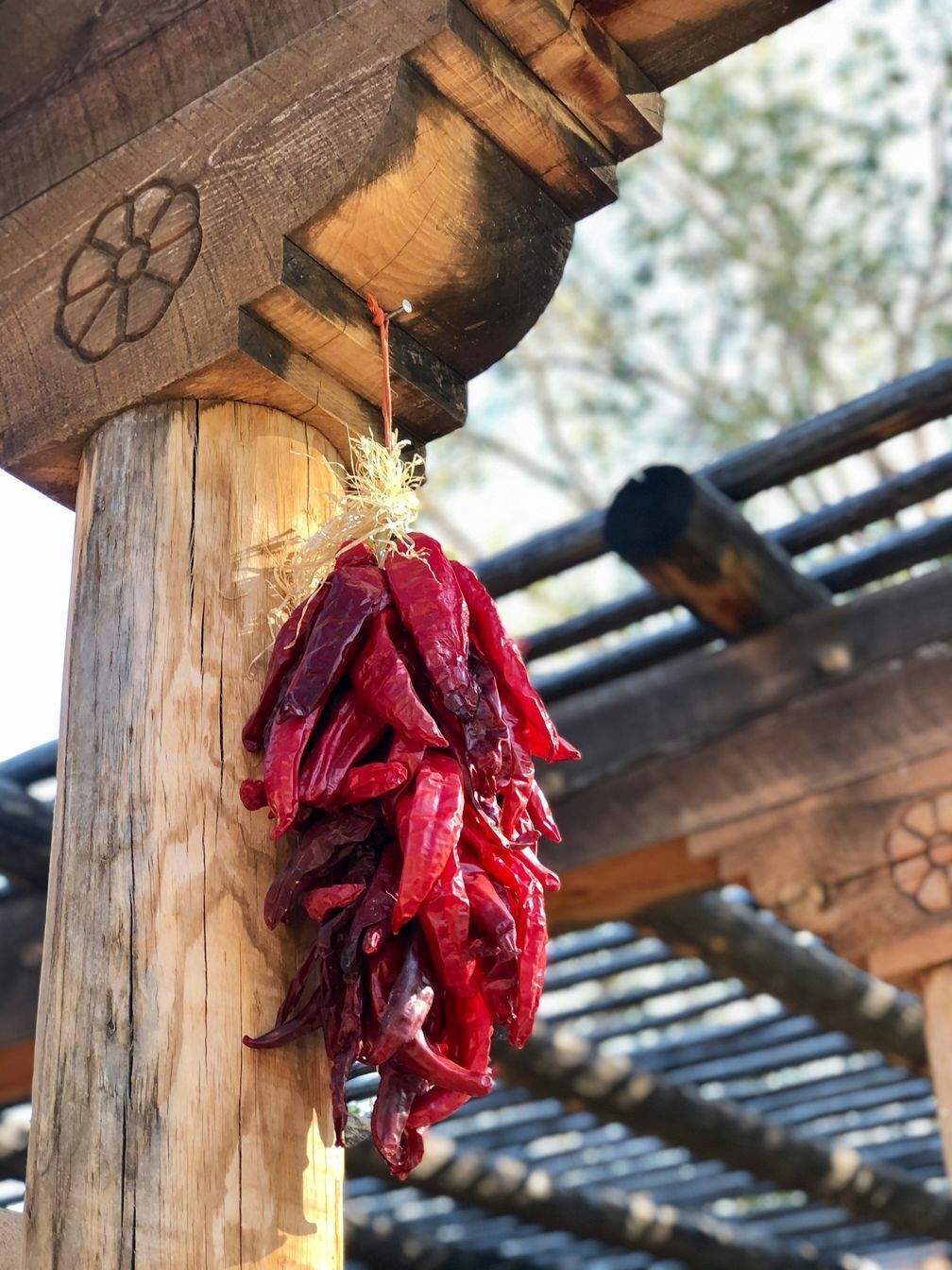 A chile ristra hanging from a wooden column