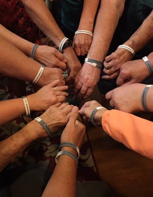 Group of arms wearing bracelets.