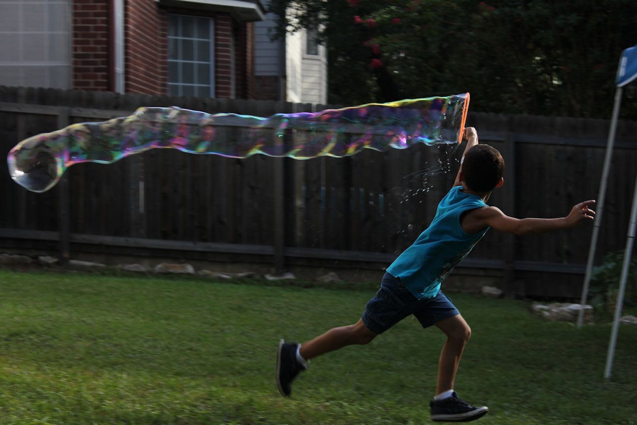 Boy running outside with giant bubble