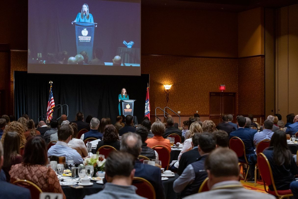 photo of Gov. Sarah Sanders speaking at a podium to large room of people