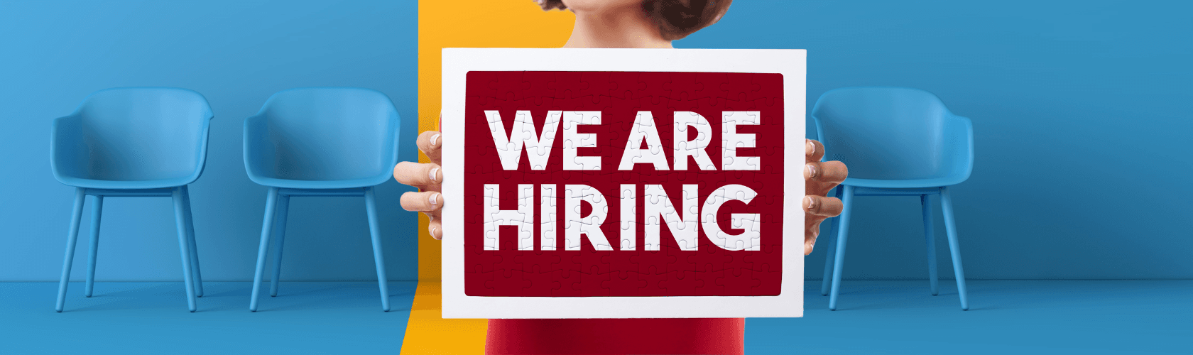 blue chairs with a yellow highlighted chair. Women holding sign that says "we are hiring"