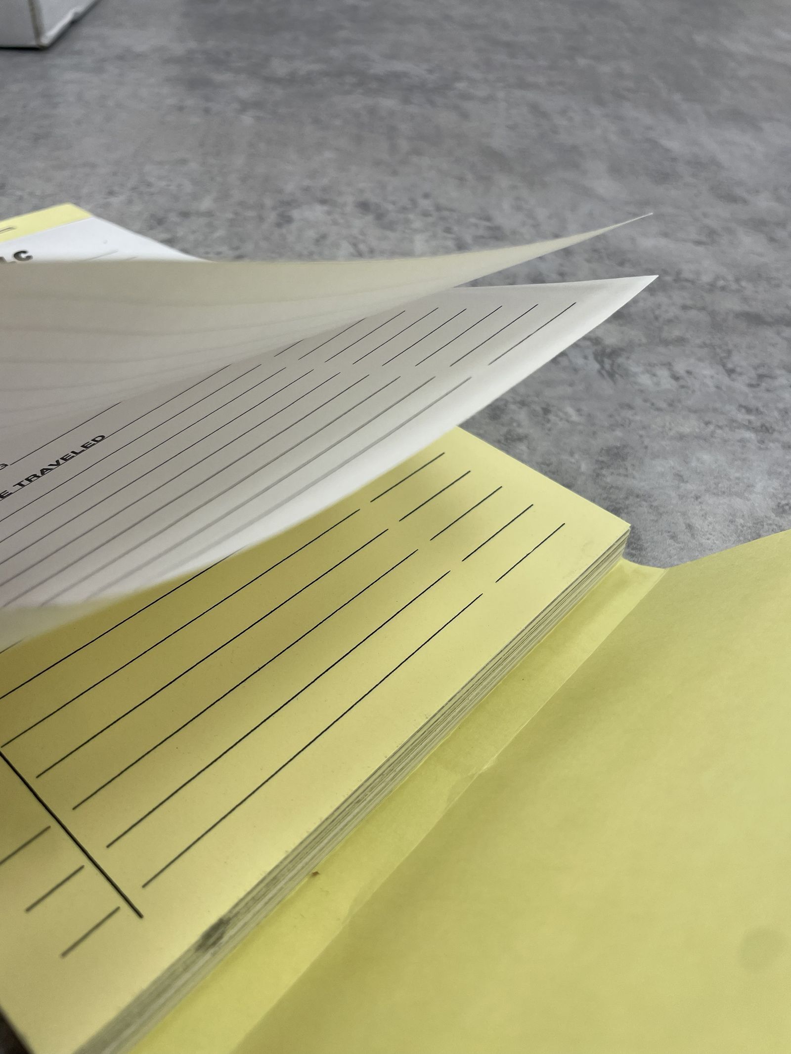 A closeup on a stack of invoices being flipped through.