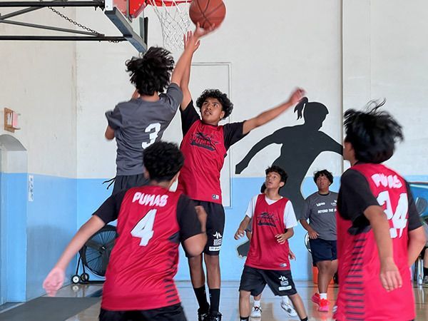 Youth taking a jump shot during a basketball game.