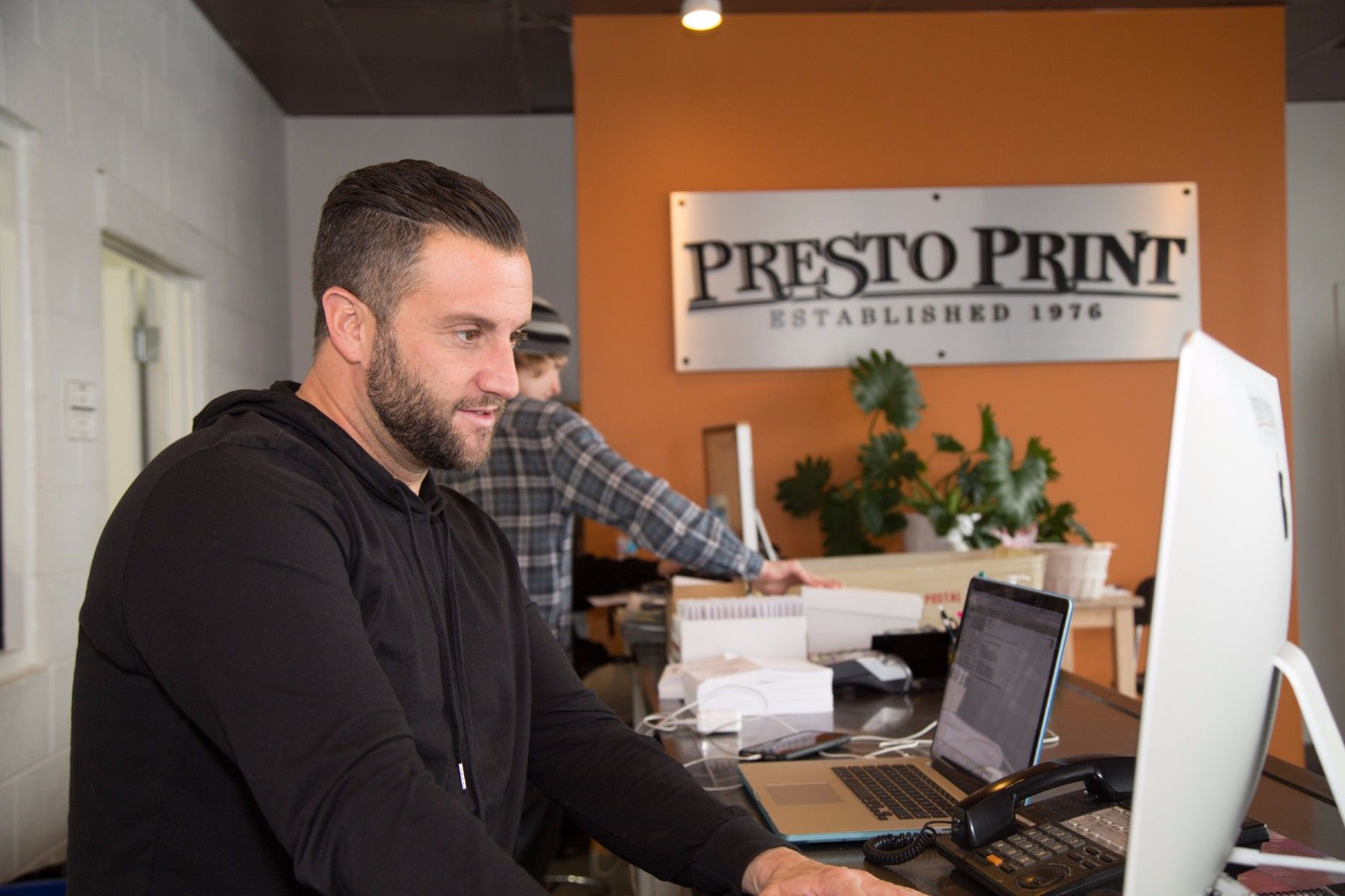 Presto Print employee offering printing services