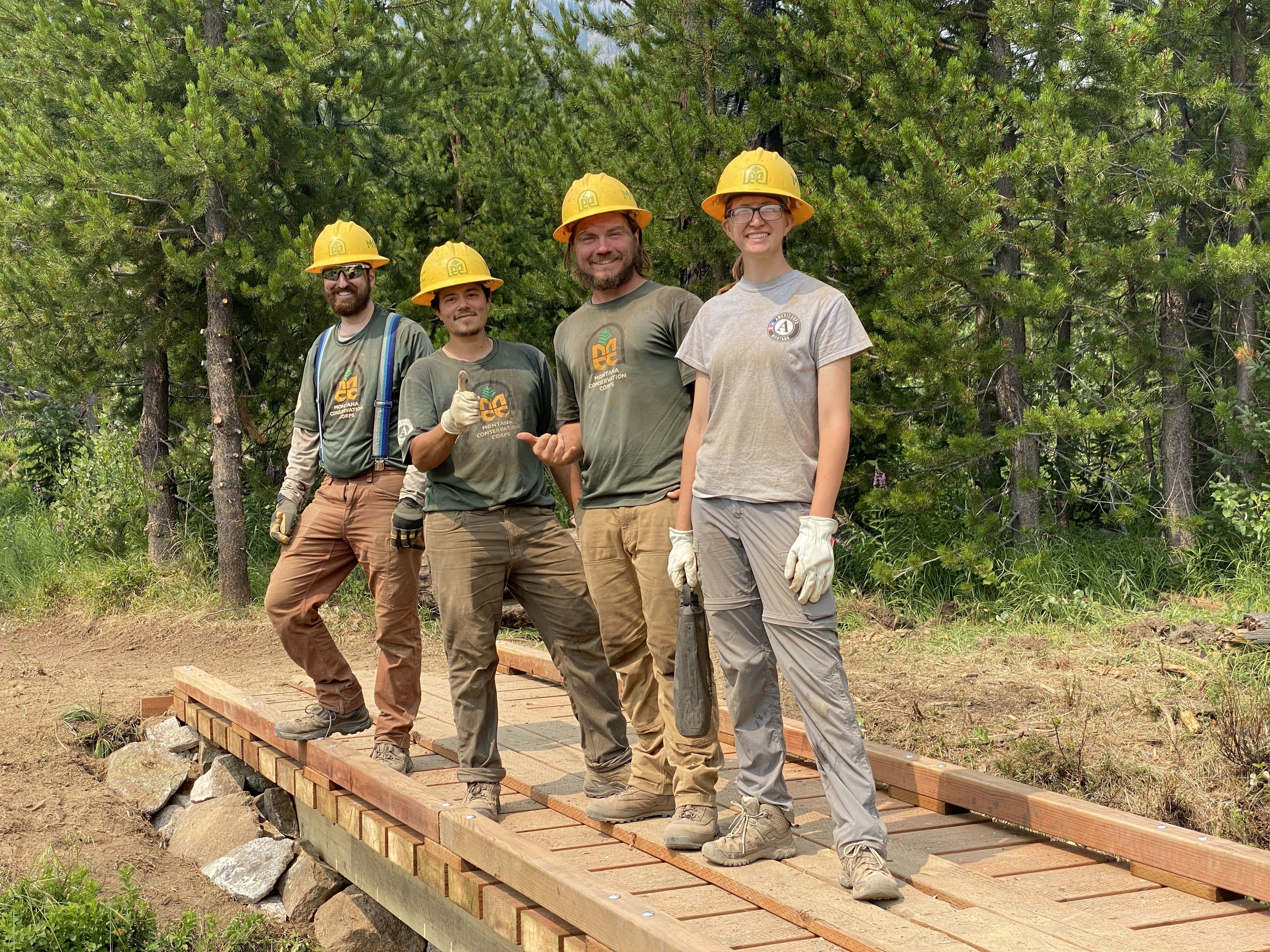 A crew stands on a bridge that they just repaired