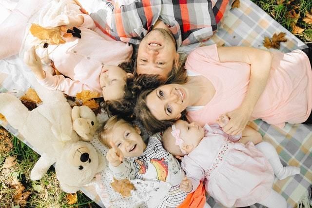 Family laying down on blanket together