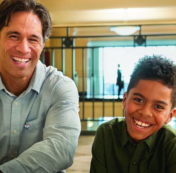 Boy and man smiling and laughing together.