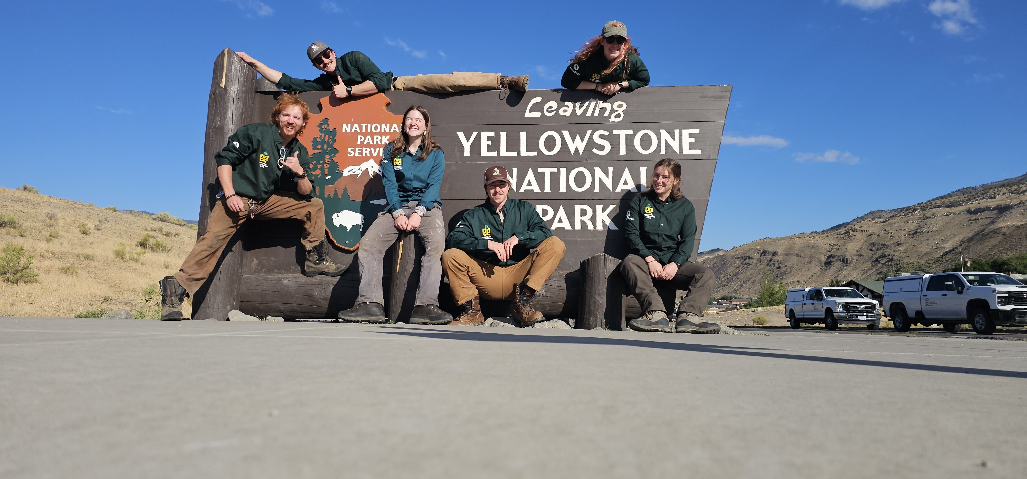 The crew poses with the "Leaving Yellowstone National Park" sign
