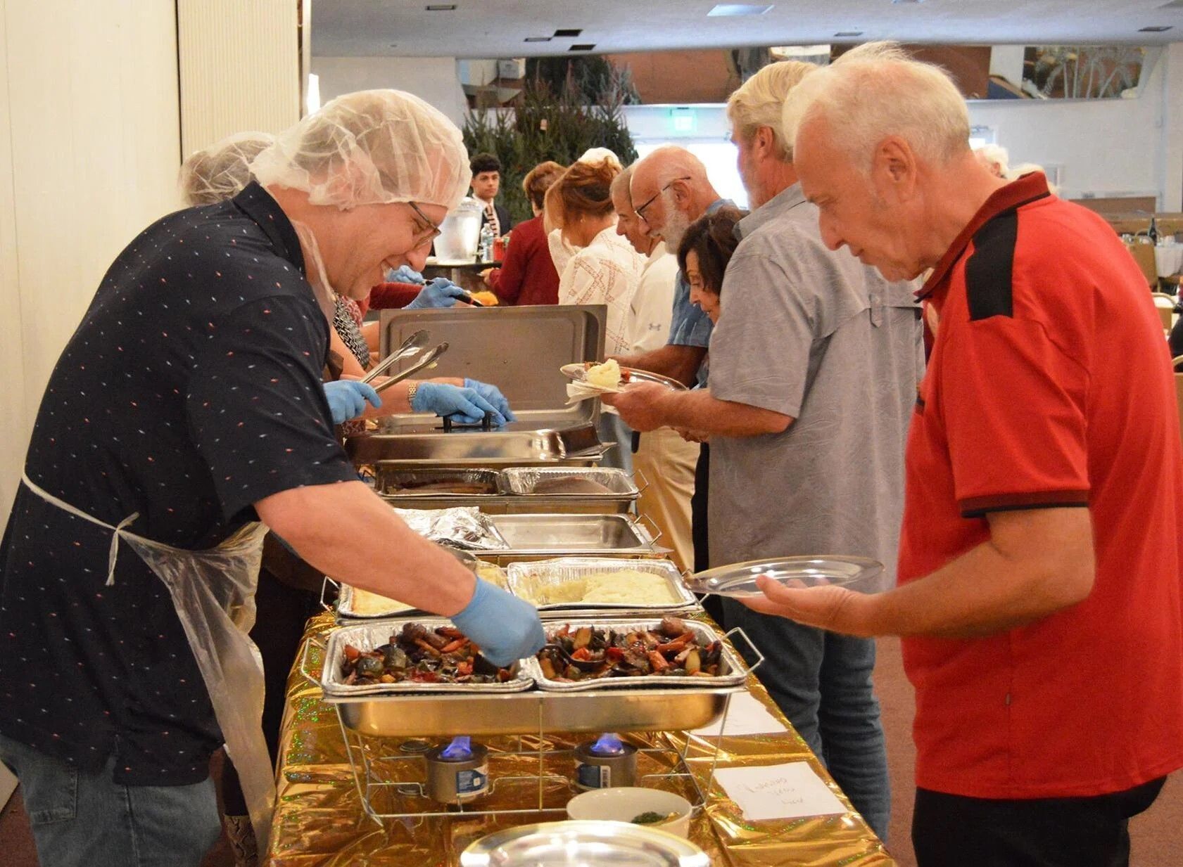 Volunteers in Highland Beach serve Thanksgiving dinner to their neighbors in the parish social hall.