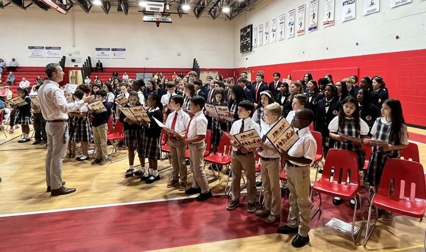 The fourth-grade choir and performance ensemble, directed by Chris Hogan, perform the "Star-Spangled Banner."