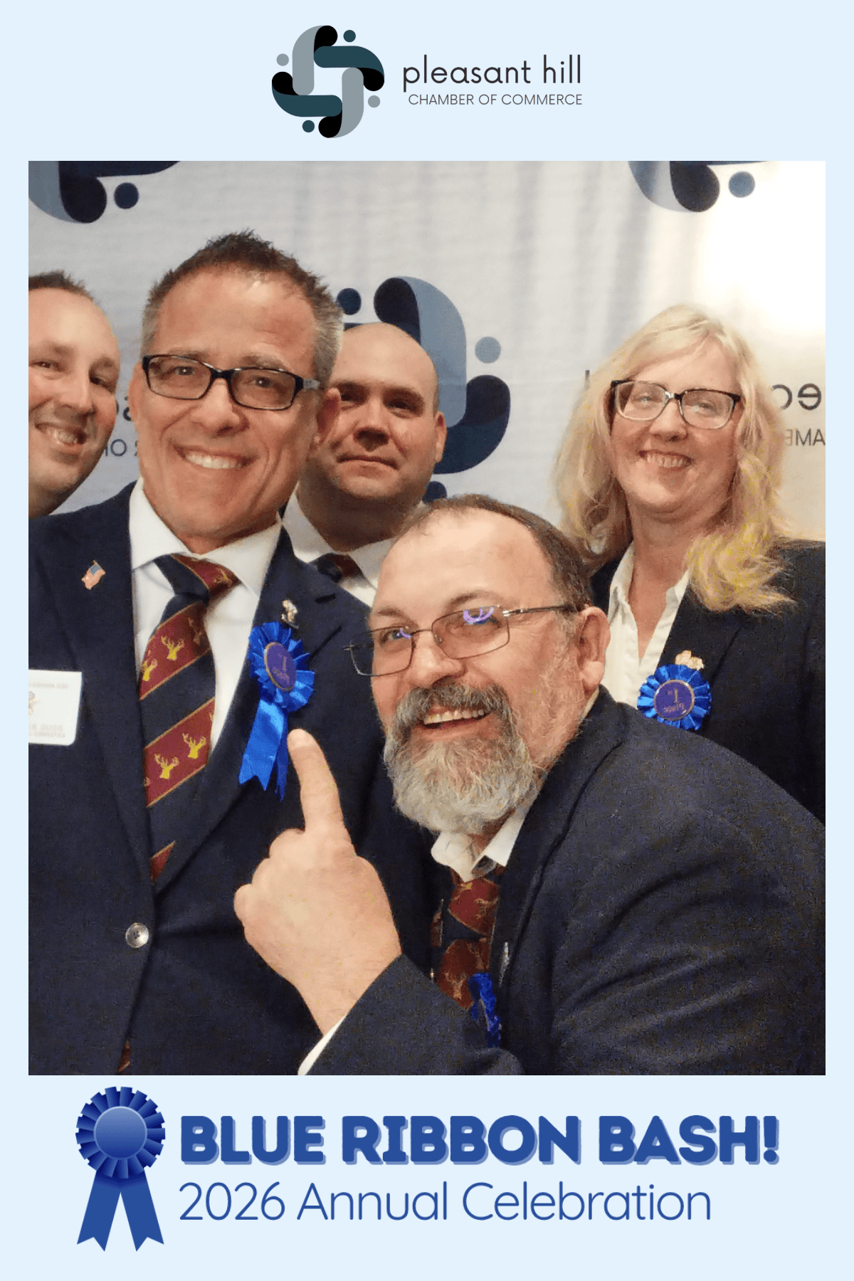 Group of smiling attendees in formal attire at Pleasant Hill Chamber event, wearing blue ribbons, promoting the “Blue Ribbon Bash! 2026 Annual Celebration.”