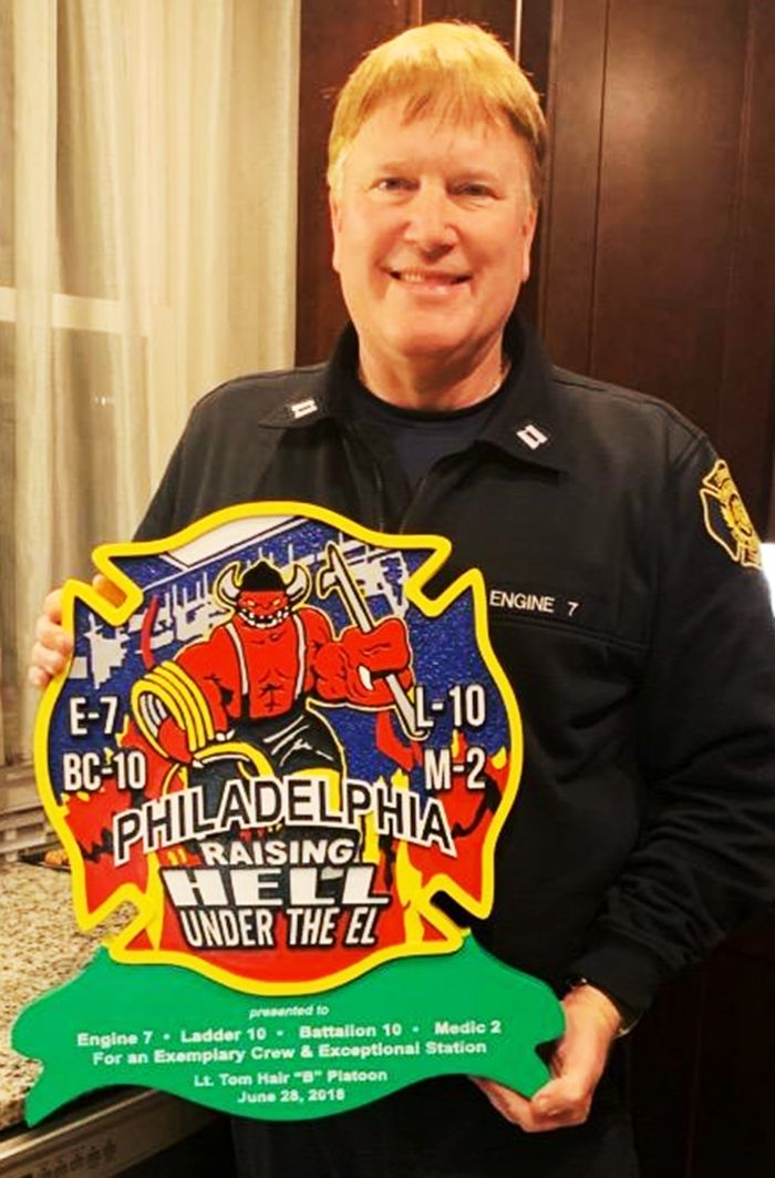 QP-3015 - Firefighter Holding the Logo for   Engine 7, Ladder 10,  of the Fire Department in Philadelphia