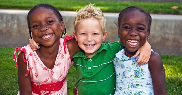 Three smiling children - CASA for Children
