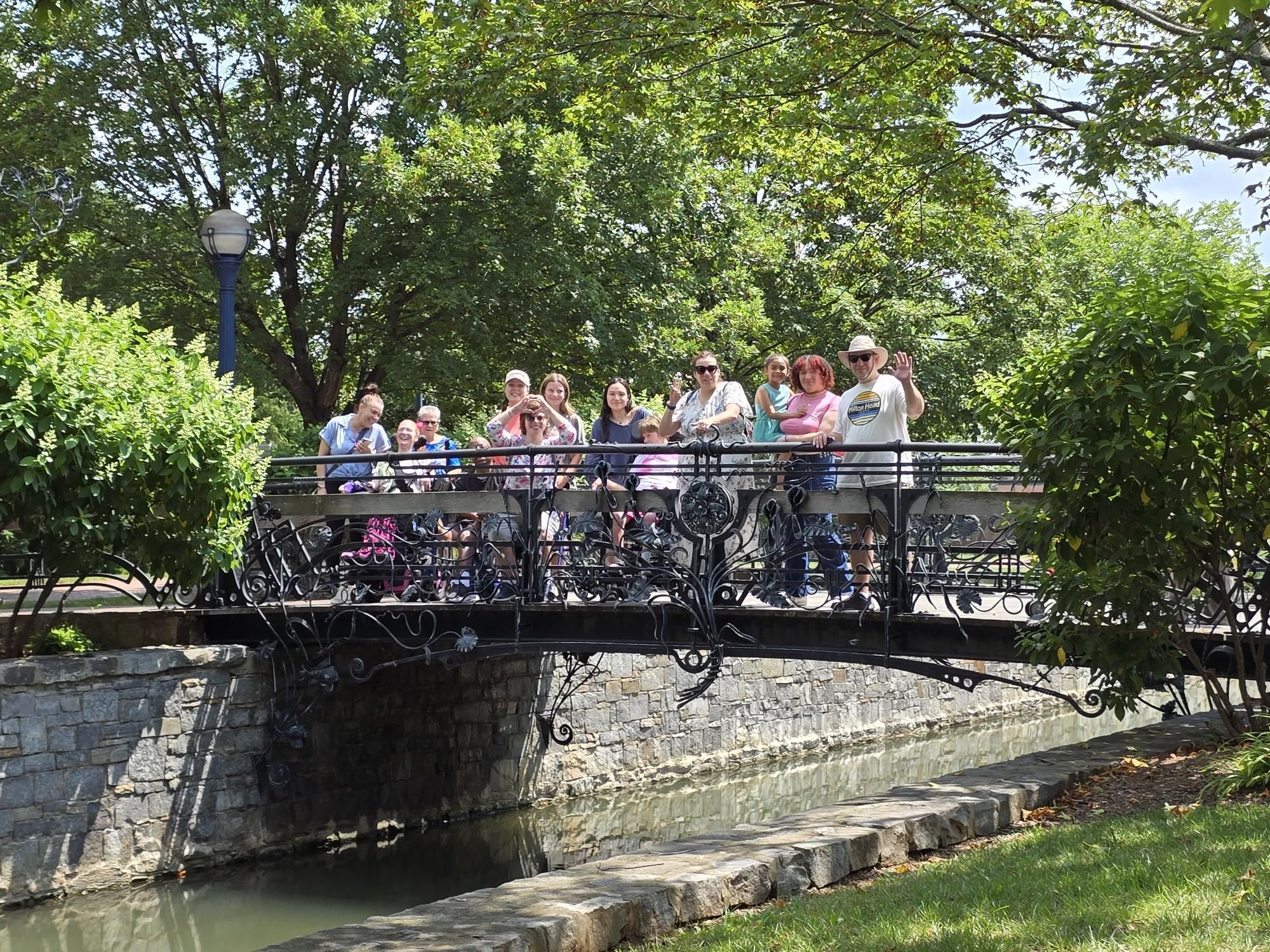 Group of people standing on a park bridge.