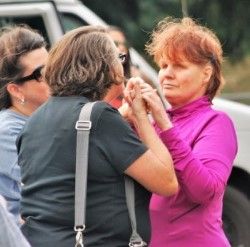 Woman using tactile sign language to communicate with woman who is deaf and blind