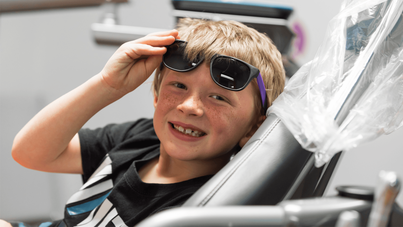 boy wearing sunglasses in a dentist's office