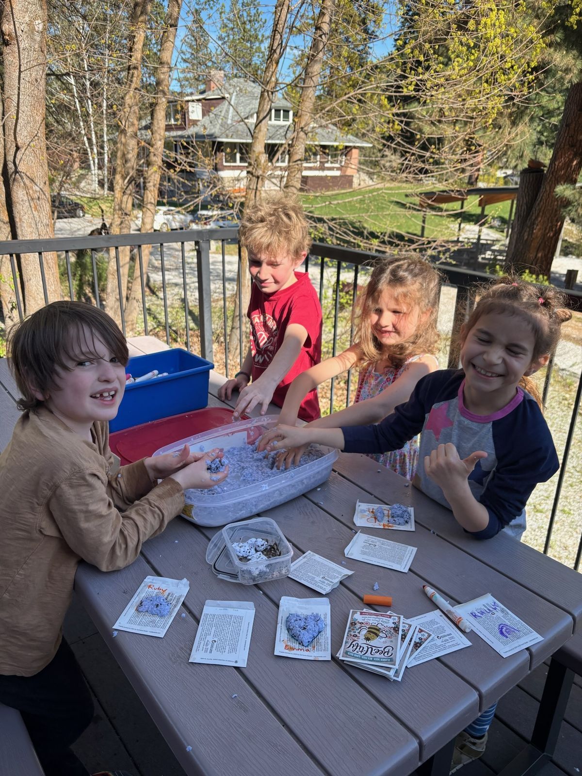 A group of students posing on a picnic table in the middle of a seed craft.