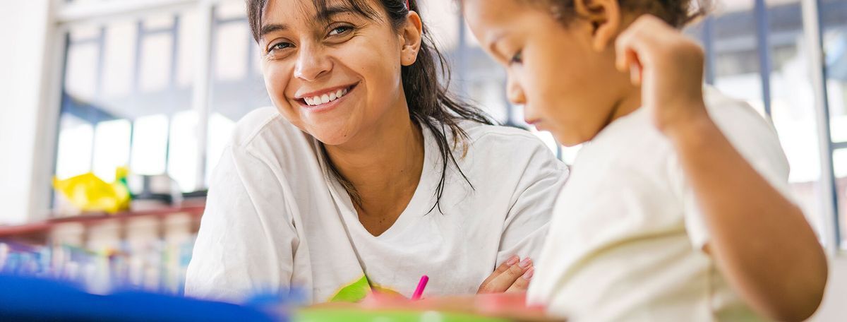 Smiling child care teacher with boy
