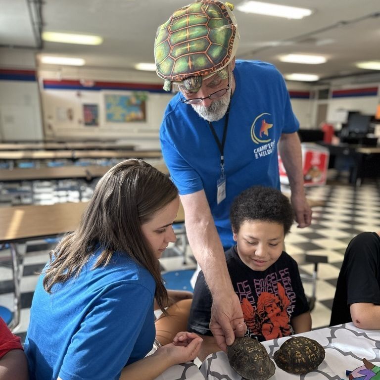Adult and student making clay sculptures of the Hellbender