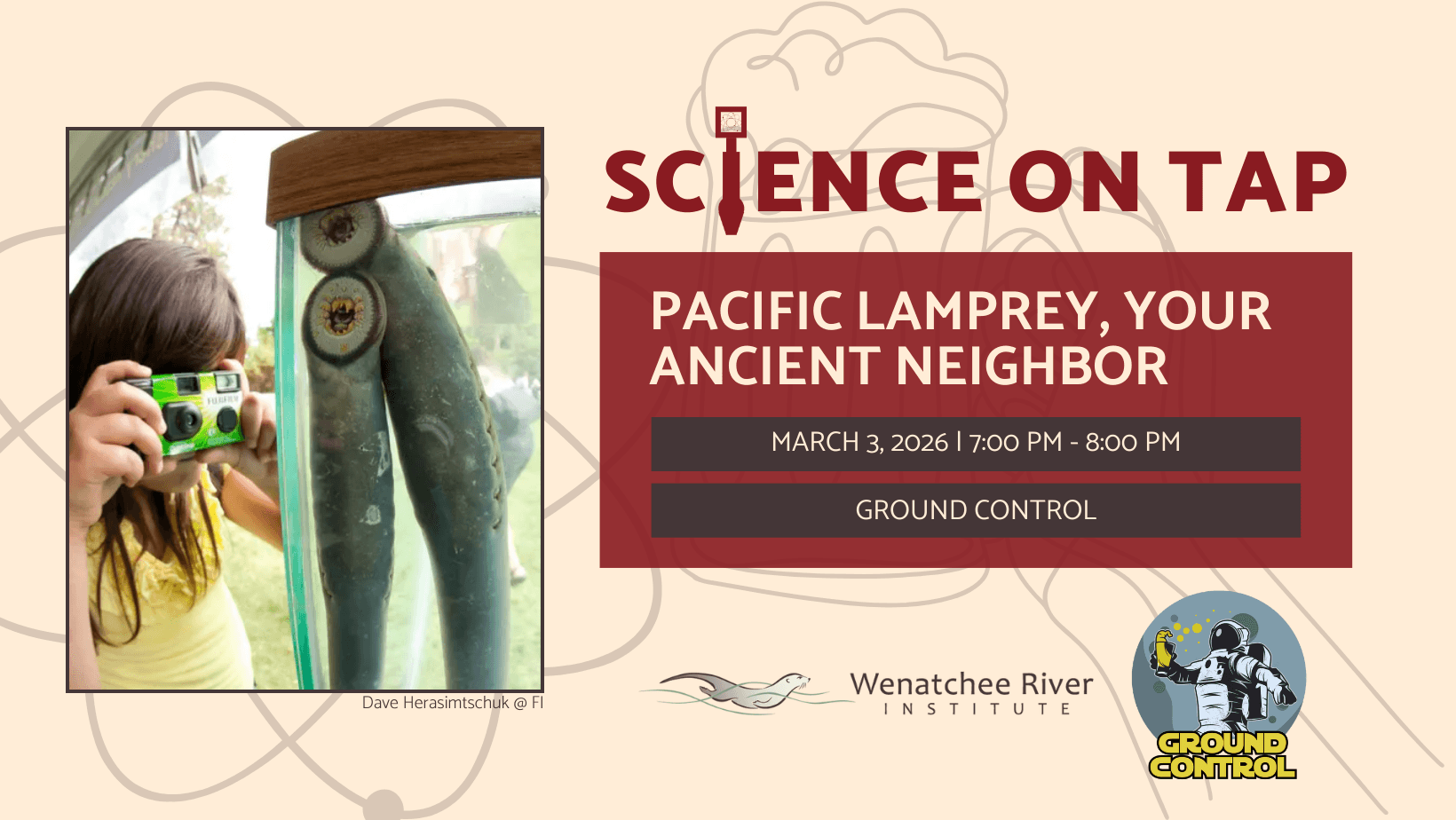A young girl with long hair uses a disposable camera to take a picture through a clear fish tank of two lamprey- long skinny, eel-like fish with rings of teeth attached by sucker to the tank wall