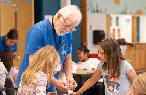 Volunteer helping students to work with clay