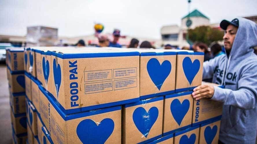 Volunteer loading food distribution boxes