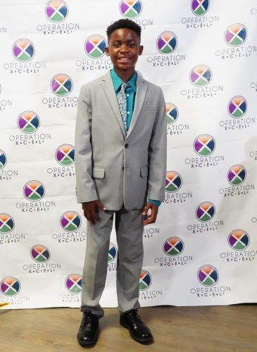 Jayden dressed nicely and smiling for a picture at Operation Xcel's 16th anniversary gala.