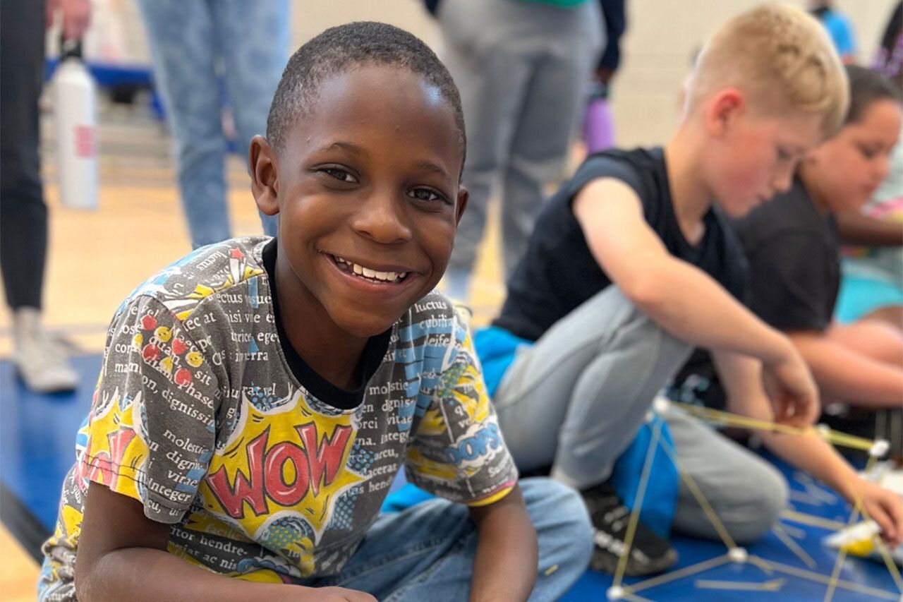 A smiling boy in a colorful shirt.